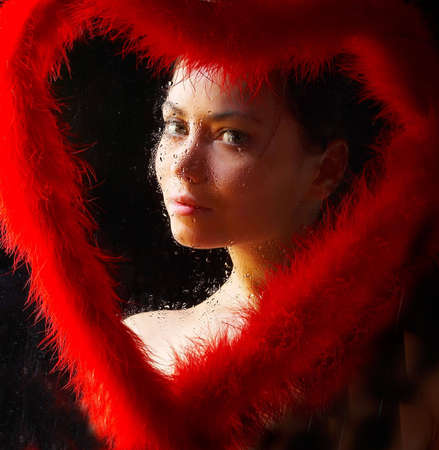 pretty brunette as a valetine's queen surrounded by red boaの写真素材