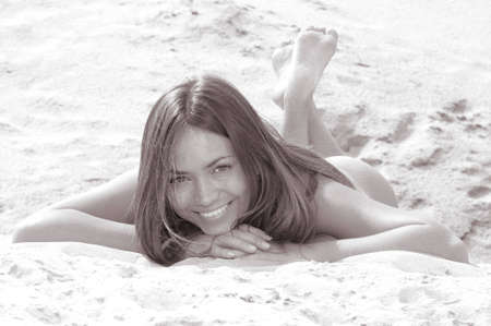 portrait of the girl which smiles sunbathing on a beachの写真素材