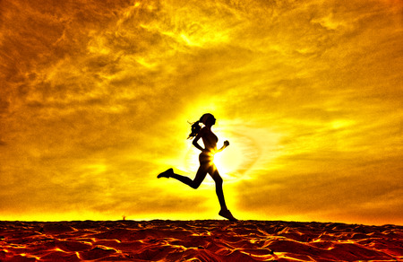 Silhouette of a girl running on the background of clouds the effect of filmの写真素材