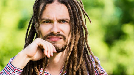 portrait of stern man with dreadlocks on a green backgroundの写真素材