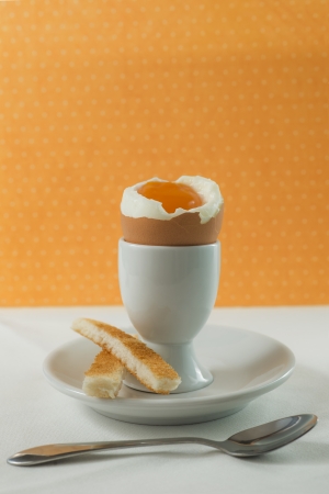 Soft-boiled egg for breakfast on yellow backgroundの写真素材