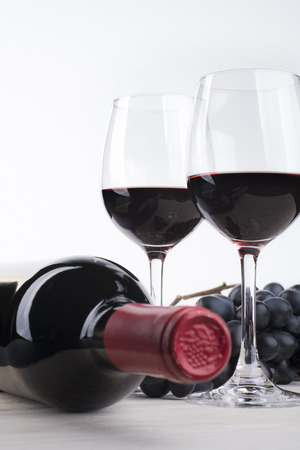 Bottle of red wine and two glasses on white backgroundの写真素材