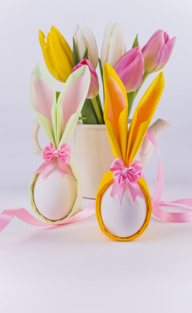Bunny napkin eggs for easter and flowers on white backgroundの写真素材