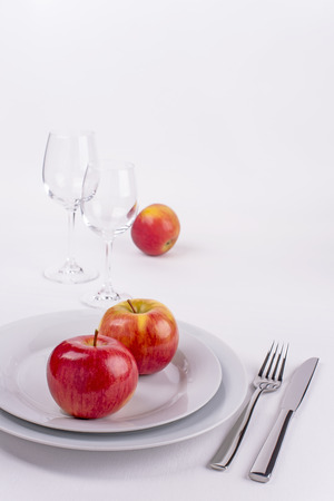 Tables decorated with plates, lady alice apples, silverware for menu and invitationの写真素材