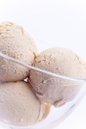 Vanilla creme brulee ice cream balls in glass bowl vertical on white backgroundの写真素材