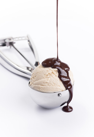 Vanilla creme brulee ice cream scoop with chocolate pouring isolatedの写真素材