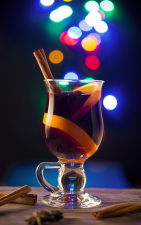 Glass with hot wine on dark background with bokeh effectの写真素材