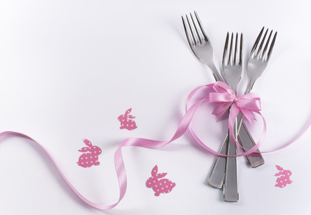 Silverware on white with pink ribbon as background for menu and invitationの写真素材