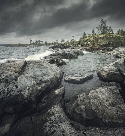 Waves of stormy sea break on rocky shore. Square layout for travel storiesの写真素材