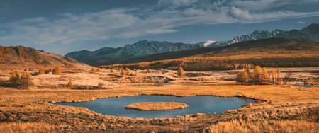 Sunset at mountain valley lake. Yellow grass and blue sky. Fall colors. Beautiful Altai panoramic landscape. Scenic viewの写真素材