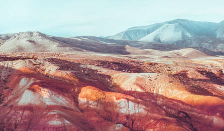 Red mountains of Altai regions. Blue peaks in the background. Folded texture.の写真素材