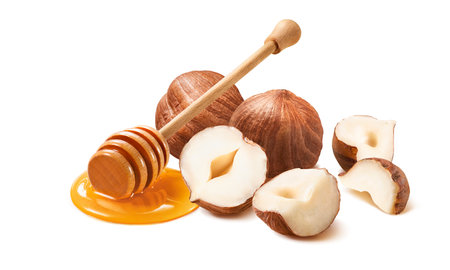 Hazelnuts and honey dipper isolated on white background. Package design element with clipping pathの写真素材