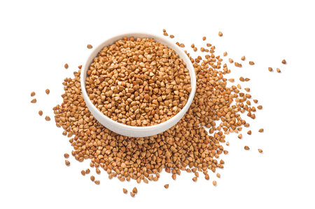 Full buckwheat bowl in the middle of buckwheat pile isolated on white background. top view. Package design element with clipping pathの写真素材