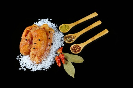Delicious caviar, roe closeup, pike caviar flat lay on sea white salt, red hot pepper, laurel leaves, wooden spoons with spices on a black background, top view, set.の写真素材