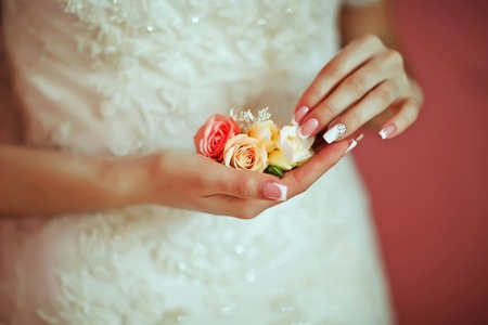 Beautiful delicate flower wedding bouquet with white and pink roses in the hands of the bride, morning of the bride.の写真素材