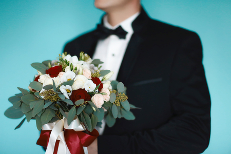 Good morning cooking, beautiful bride, dressed and preparing for a wedding, in a suit with a bouquet of flowers.の写真素材