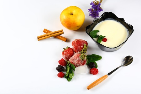 Frozen raspberry, blackberry, strawberries, yoghurt plate, mint leaves, slices of lemon, apple, wheat, on a white background top view close up setの写真素材
