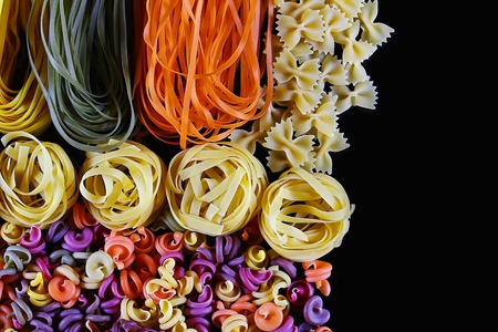 Set of different kinds of colorful Italian pasta, on a black background, healthy food concept, close-up, place for text.の写真素材