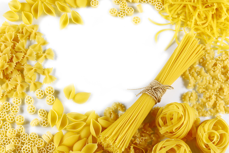 Food concept - various uncooked, raw Italian pasta on white background, top view, place for text, set.の写真素材