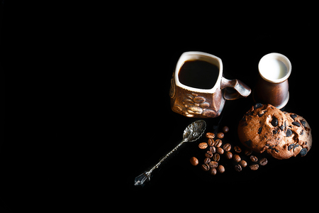 close-up cup of espresso coffee, milk and spoon Vintage, round crunchy chocolate cookies with coffee beans on a black background, macro, empty space for text, top view, set.の写真素材