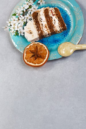 Homemade chocolate pastry with cream and bezia, dessert on a blue ceramic plate, with a yellow...