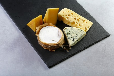 Cheese plate. Assortment of cheese on a stone plate. close up. set.
