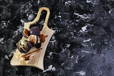 Gourmet appetizer of figs with dorblyu cheese, walnuts and honey on a wooden board a dark background, traditional Turkish dessert, . top view.の写真素材