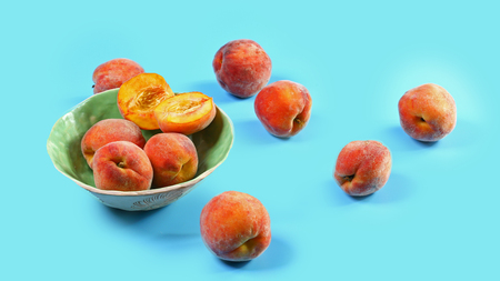 Ripe fruit peachs on a plate blue background. Seasonal harvest crop local produce concept. Authentic...
