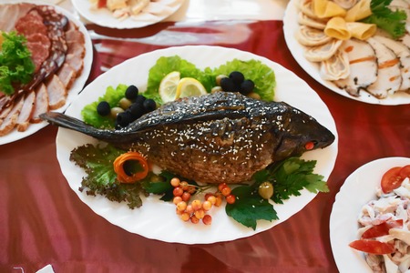 Catering service. Stuffed fish on the table Restaurant table with food on the table. Plates of food....