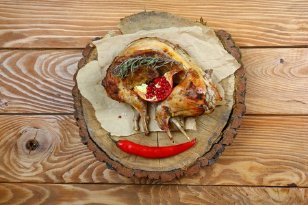 Roast baked whole rabbit on wooden board on paper. Ingredients for baked rabbit rosemary on rustic oak table. A festive meal. Top view.の写真素材