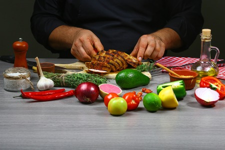 Cooking meat steak, vegetables and spices with by chef hands on wooden background. Food recipe concept.の写真素材