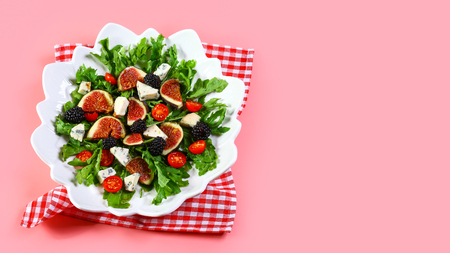 Fig, arugula and cheese salad Isolated on pink background. top view copy space.の写真素材