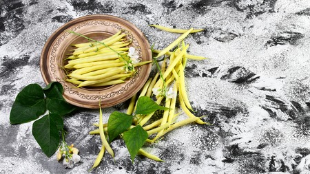 Organic yellow wax bean on an earthenware plate. top view copy space.