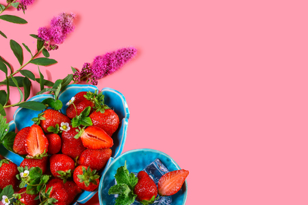 Fresh nice strawberries on a blue plate isolated on pink background. Copy space. Top view, High resolution product.の写真素材