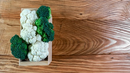View of organic broccoli and cauliflower in the box. Seasonal harvest crop local produce concept. Authentic lifestyle image. Flat lay. Top view.の写真素材