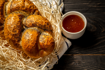 Traditional jewish bread brown challah on black wooden background with honey. concept of jewish cuisine. A table set for Shabbat. Flat lay.の写真素材