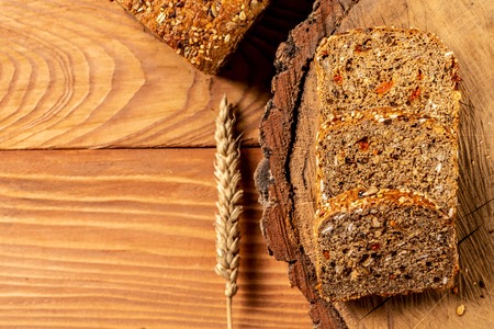 goji berry bread. Sliced rye bread on a wooden stump, with wheat. Whole grain rye bread with seeds,...