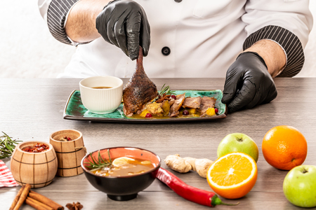 Chef serving dish of duck. Roasted Duck with orange sauce for the Holidays Chinese restaurant at the Chinese new year season. place for text.の写真素材