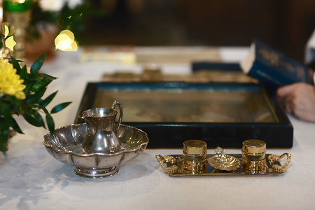 Tools for baby baptism. eley in the hands of a priest. Catholicism, the concept of Christianity.