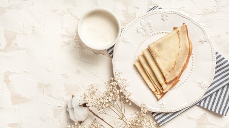 Crepes, thin pancakes with honey on a white plate. Top view. Flat lay. space for text.の写真素材