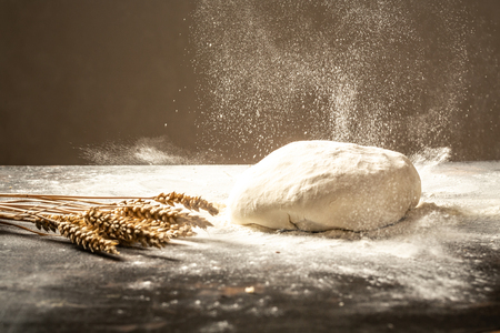 fresh raw dough ball. White flour flying into air. Food concept.の写真素材