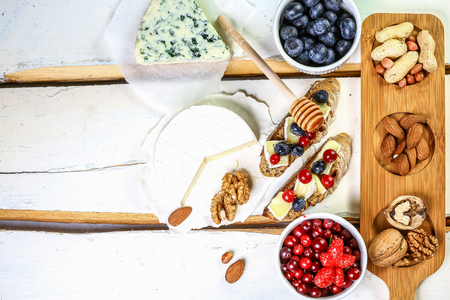 Fruit Bruschetta with cheese, fresh berries, walnuts, against a white background. Flat lay. copy text.の写真素材