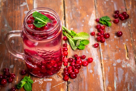 Health care, fitness, healthy nutrition diet concept. refreshing summer drink of berries with mint and ice. infused water, cocktail, detox drink in a glass jar.の写真素材