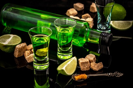 absinthe shots with sugar cubes and lime isolated on black background.の写真素材