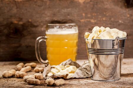 snack for beer. Glass of beer and cheese on cutting board on brown vintage background. pace for textの写真素材