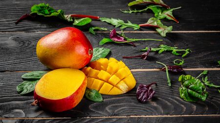Mango tropical fruit on a dark wooden background. Flat lay. place for text. Food concept.の写真素材