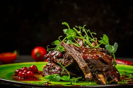 stewed ribs with sauce on a plate decorated with pea seedlings.の写真素材