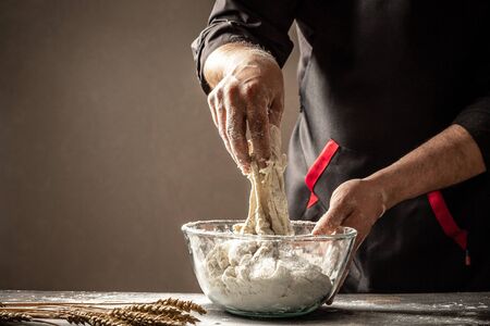 Cooking bread. Kneading the Dough. Isolated on dark background. Empty space for text