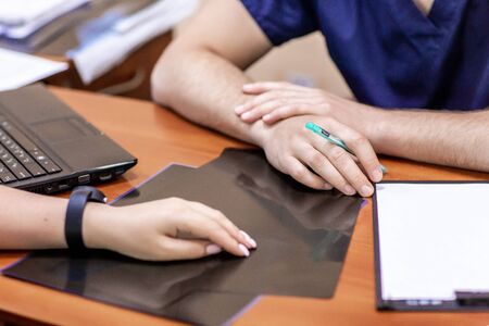 Doctor and female patient sitting at the desk and talking in clinic. Medicine and health care concept.の写真素材