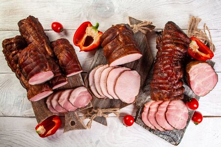 Set delicious smoked ham on a wooden board with spices. Traditional Sliced Ham.
